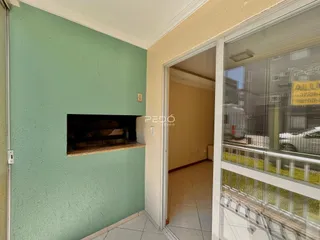 Hall de entrada com parede verde e porta de vidro em um imóvel no Brasil.