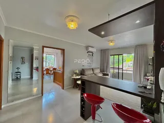 Ambiente interno de uma sala de estar com vista para o exterior.