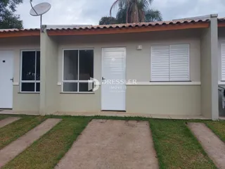 A fachada de uma casa em Lajeado, Brasil com paredes bege e telhado de telhas.