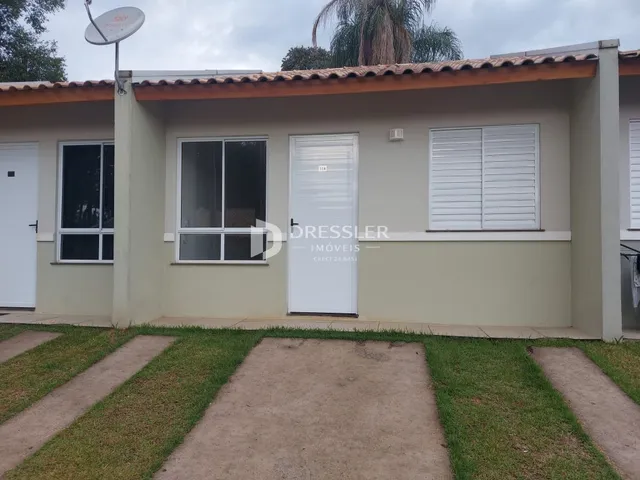 A fachada de uma casa em Lajeado, Brasil com paredes bege e telhado de telhas.