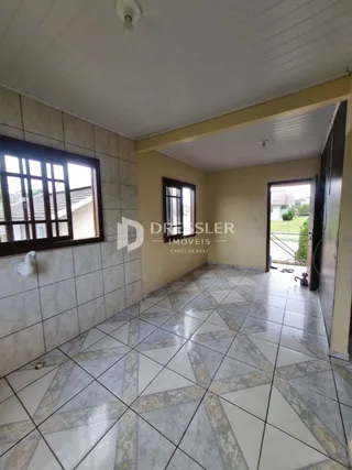 Vista interna de um ambiente com piso de cerâmica e janela em uma residência.