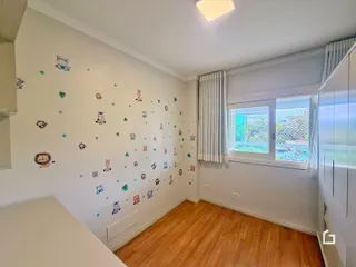 Ambiente interno de uma sala com piso de madeira e decoração de parede.