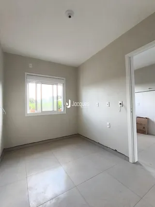 Ambiente interno de uma sala com piso de cerâmica e janela.