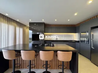 Cozinha moderna com ilha e bancos de madeira.