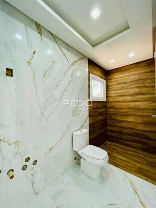 Foto de um banheiro com revestimento em mármore branco e parede de madeira.