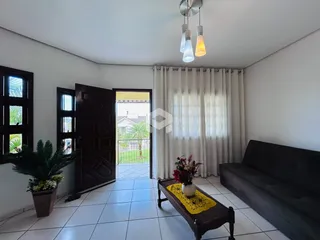 Sala de estar com portas de madeira escura e piso de cerâmica.