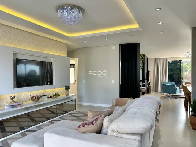 Sala de estar moderna com sofá claro e decoração elegante.