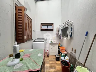 Interior de uma cozinha com armários de madeira e área de serviço.
