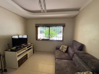 Sala de estar com sofá e televisão em um imóvel no Brasil.