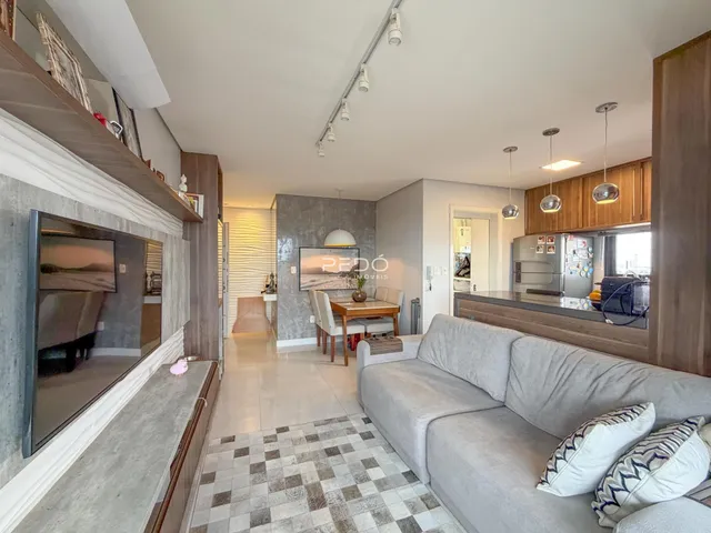 Sala de estar com sofá e lareira em um apartamento em Lajeado.