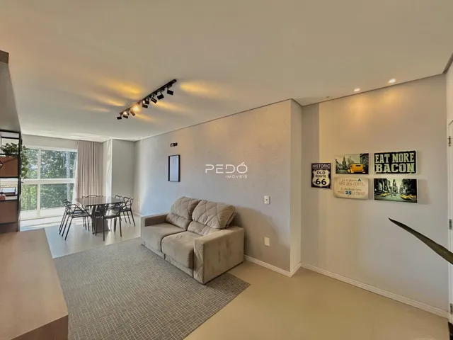 Sala de estar com sofá e área de jantar em um imóvel no Brasil.
