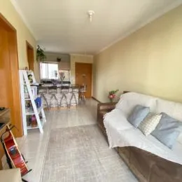 Hall de entrada com sofá e piso claro em um imóvel.
