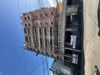 Fachada de um prédio em construção em Lajeado, Brasil, com andaimes visíveis.