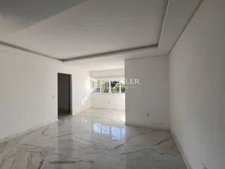 Ambiente interno amplo com piso de mármore polido.