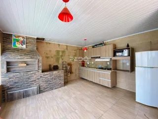 Foto de uma cozinha com armários de madeira e piso claro.