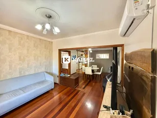 Sala de estar com sofá e piso de madeira polida.