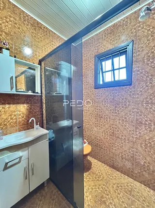 Interior de um banheiro com revestimento de cerâmica marrom.