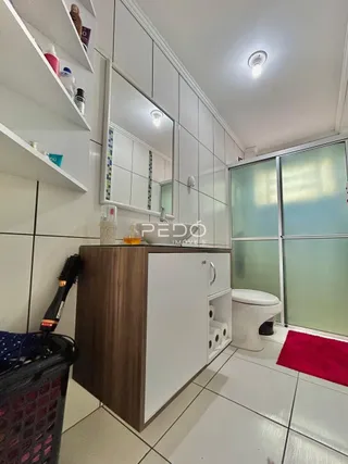 Interior de um ambiente com revestimento de piso cerâmico branco e armários brancos.