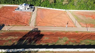 Vista aérea de uma propriedade com terreno aberto e vegetação circundante.
