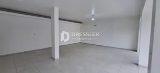 Espaço interno com paredes brancas e piso de cerâmica.