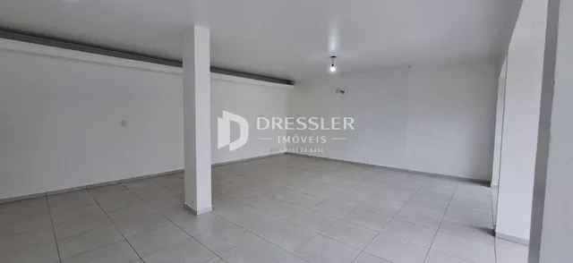 Espaço interno com paredes brancas e piso de cerâmica.