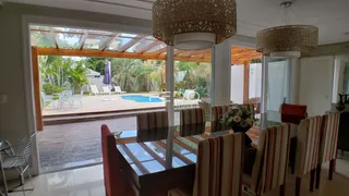 Vista da sala de jantar com vista para o pátio e piscina.