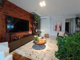 Sala de estar com parede de tijolos aparentes e móveis de madeira.