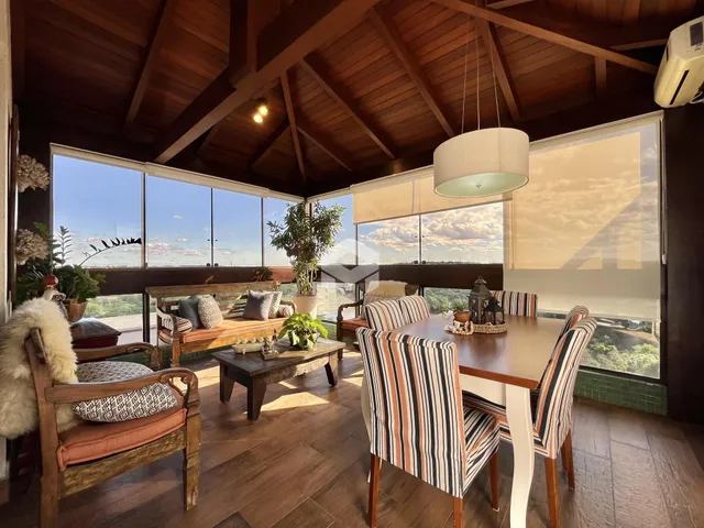 Sala de estar com piso de madeira e vista para a paisagem.