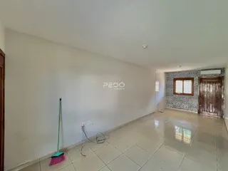 Interior de um ambiente com piso de cerâmica e paredes brancas.
