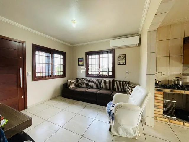Sala de estar com sofá e poltrona em um imóvel em Lajeado.