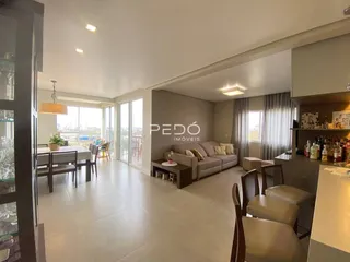Sala de estar ampla com vista para a cidade e grandes janelas.