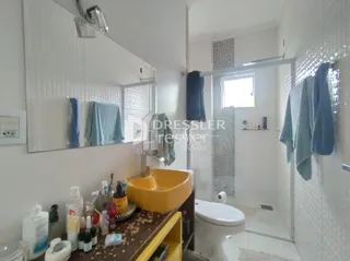 Foto de um banheiro interno com azulejos brancos e louças sanitárias.