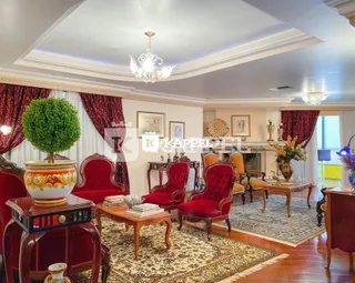 Sala de estar com cadeiras vermelhas e tapete estampado.