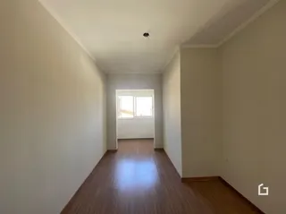 A foto mostra um corredor interno com piso de madeira.