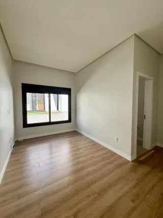 Ambiente interno com piso de madeira e janela em uma residência.