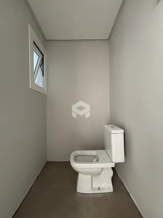 Hall de passagem com janela e vaso sanitário.