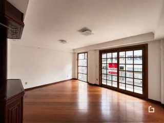 Sala de estar com piso de madeira e portas de vidro.