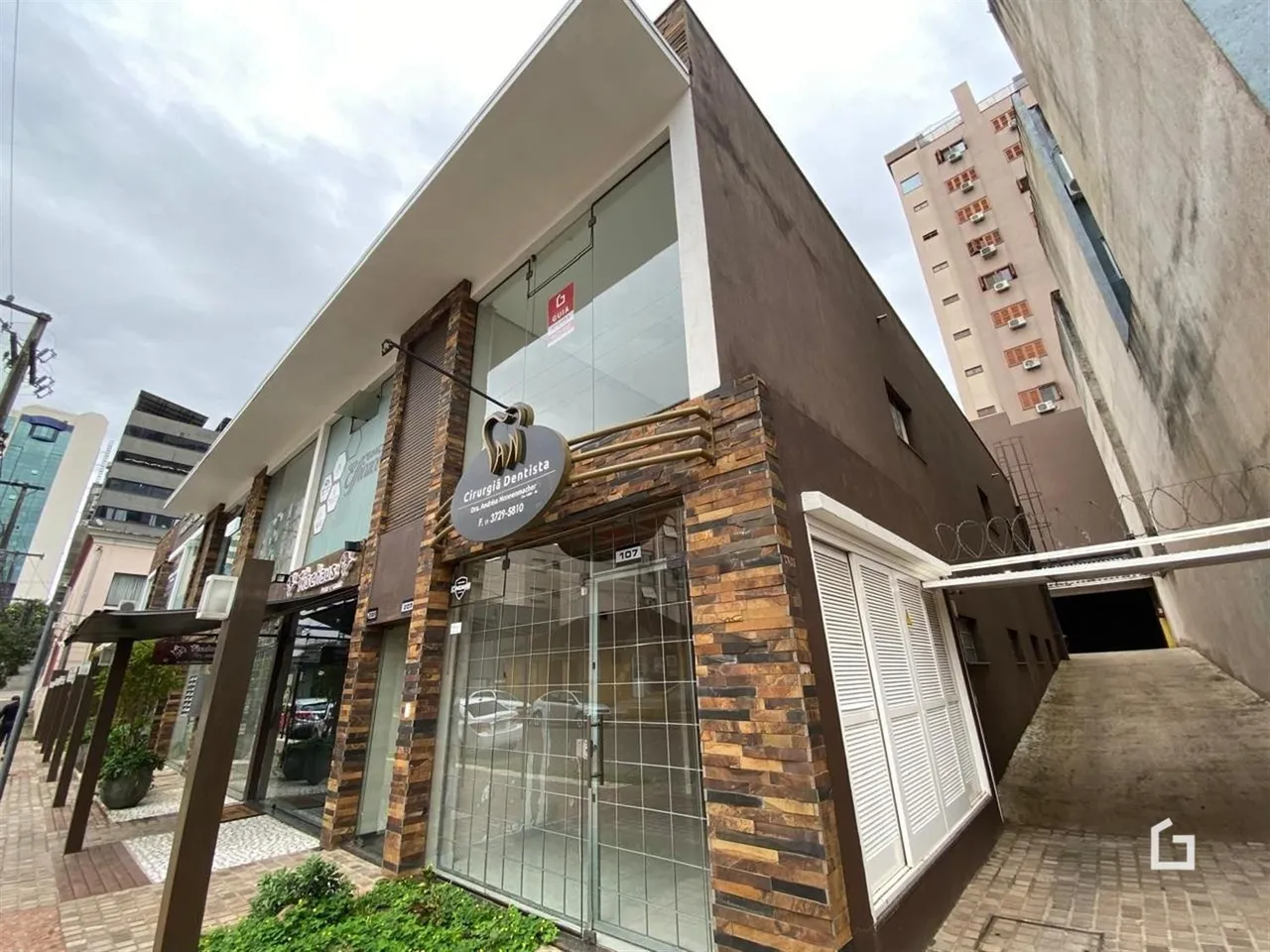 Fachada de um imóvel comercial em Lajeado, Brasil, com grandes janelas de vidro.