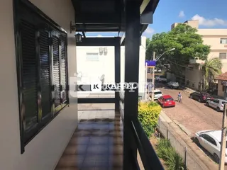 Foto de um corredor interno com portas escuras e paredes brancas.