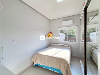 Quarto com cama e janela, com ar-condicionado instalado.