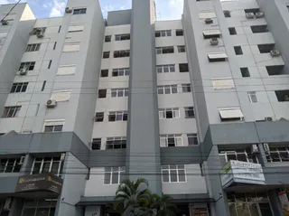 Fachada de um prédio residencial em Lajeado, Brasil, com múltiplas janelas e unidades de ar-condicionado.