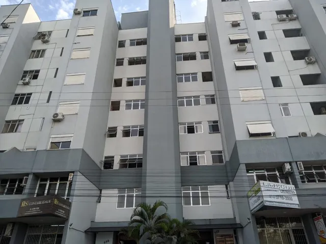Fachada de um prédio residencial em Lajeado, Brasil, com múltiplas janelas e unidades de ar-condicionado.