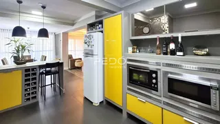Interior de uma cozinha moderna com armários amarelos e cinzas.