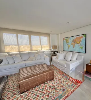 Sala de estar com sofá branco e tapete estampado.