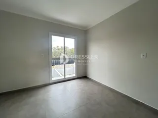 Sala de estar com grande janela de vidro voltada para o exterior.