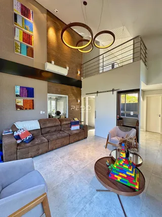 Sala de estar com sofá marrom e piso claro em um imóvel no Brasil.