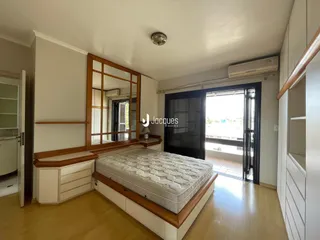 Quarto com cama e porta de vidro que dá acesso ao exterior.