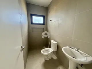 Interior de um banheiro com piso de cerâmica e paredes revestidas.