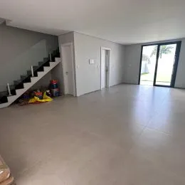 Foto de um ambiente interno amplo com escadaria e porta de vidro.