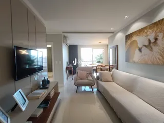 Sala de estar moderna com sofá e televisão em um imóvel no Brasil.